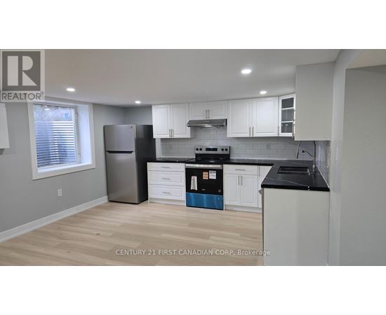 A kitchen with a refrigerator, oven, and cabinets.