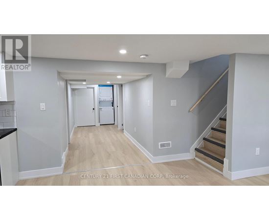 A hallway with a staircase leading to the second floor.