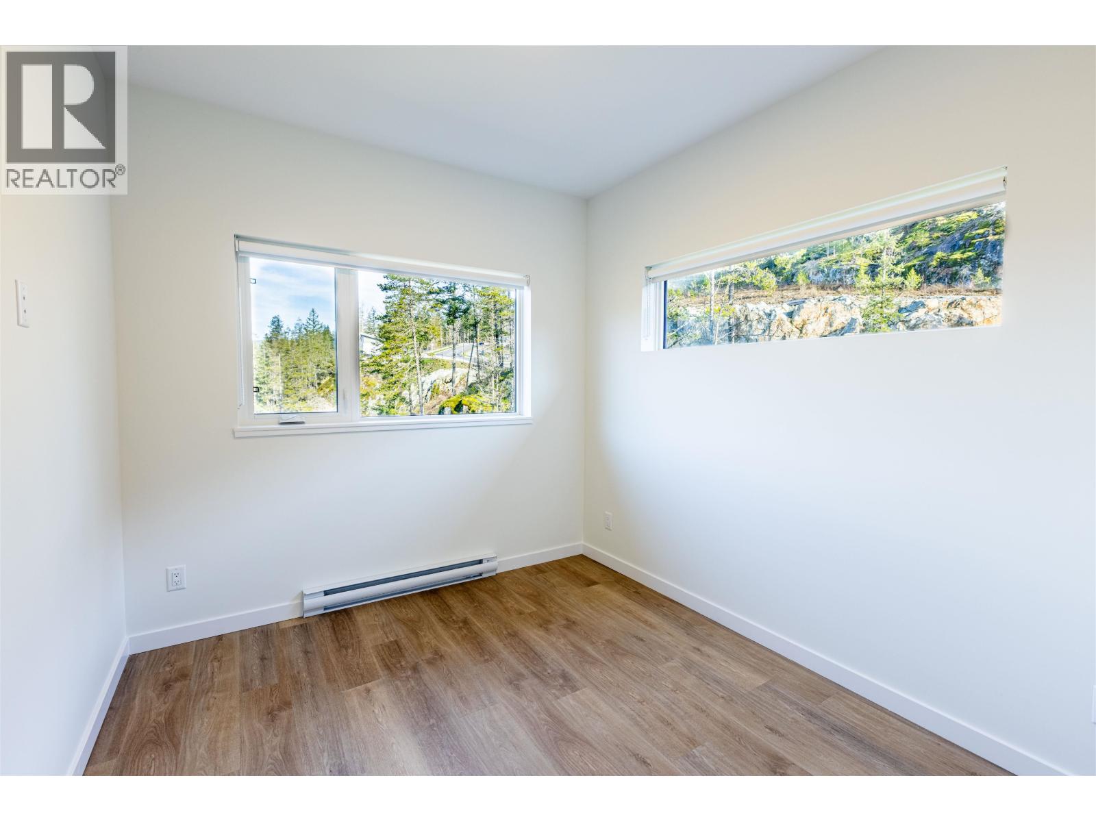 A room with a window showing trees outside.