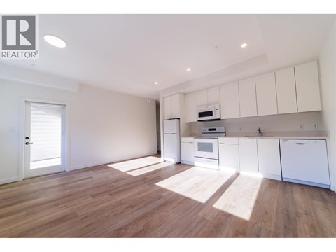 A spacious kitchen with white cabinets and a microwave above the oven.