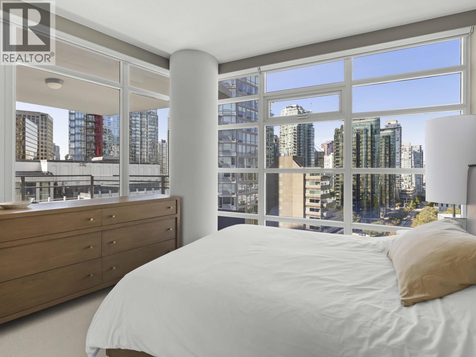 A bedroom with a large bed and a view of the city.