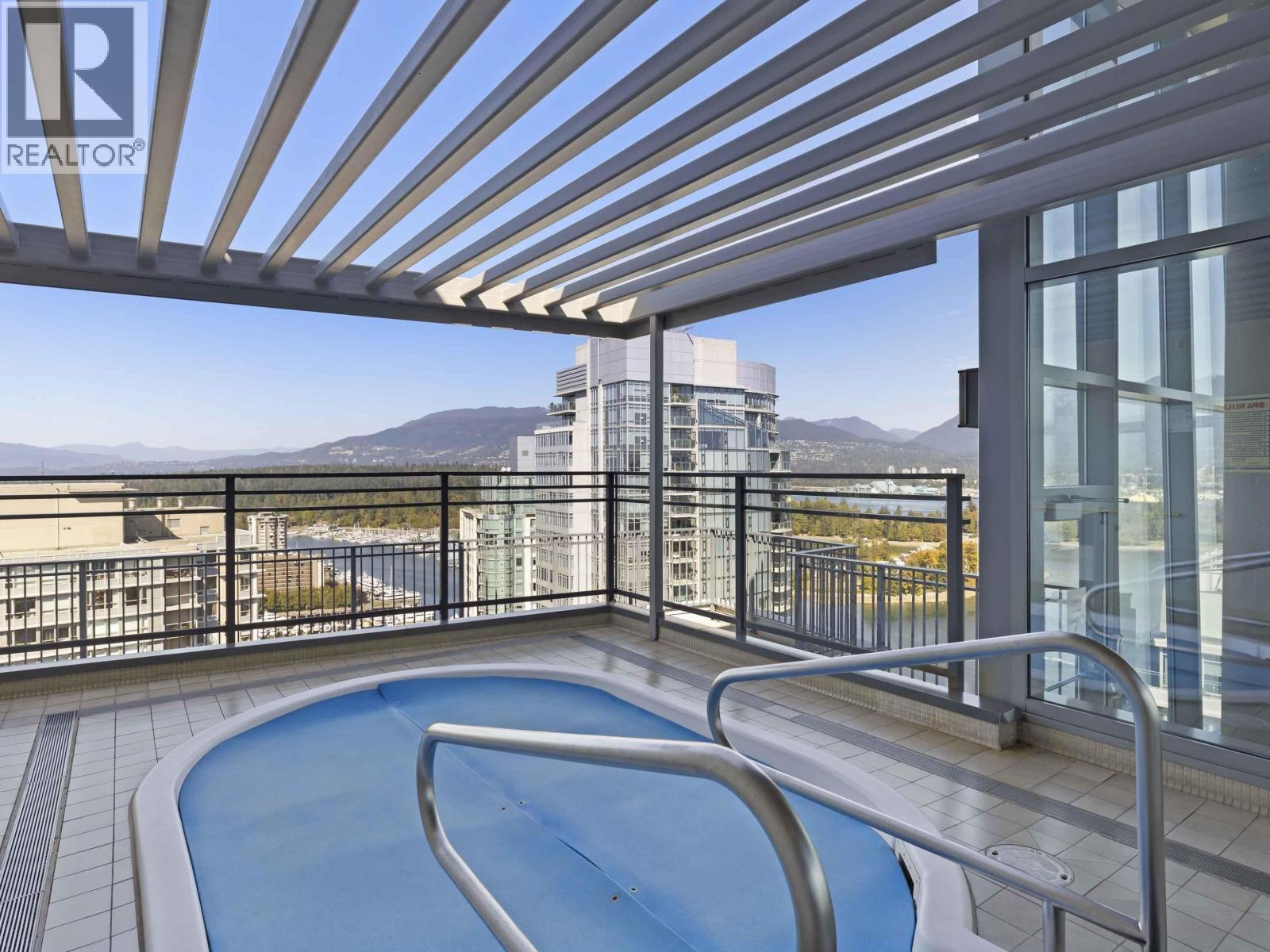 A pool on a balcony with a mountain in the background.