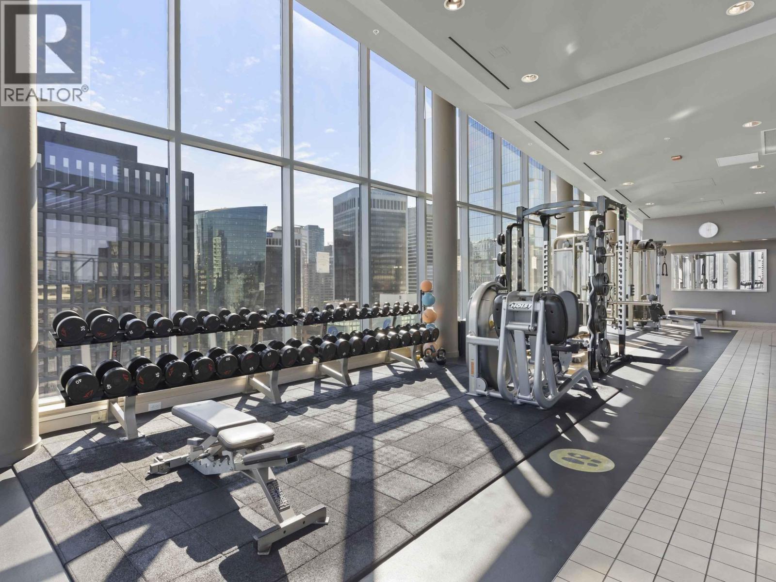 A gym with a row of dumbbells and weight machines.