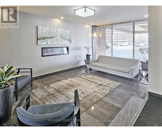 A living room with a grey couch and a rug.