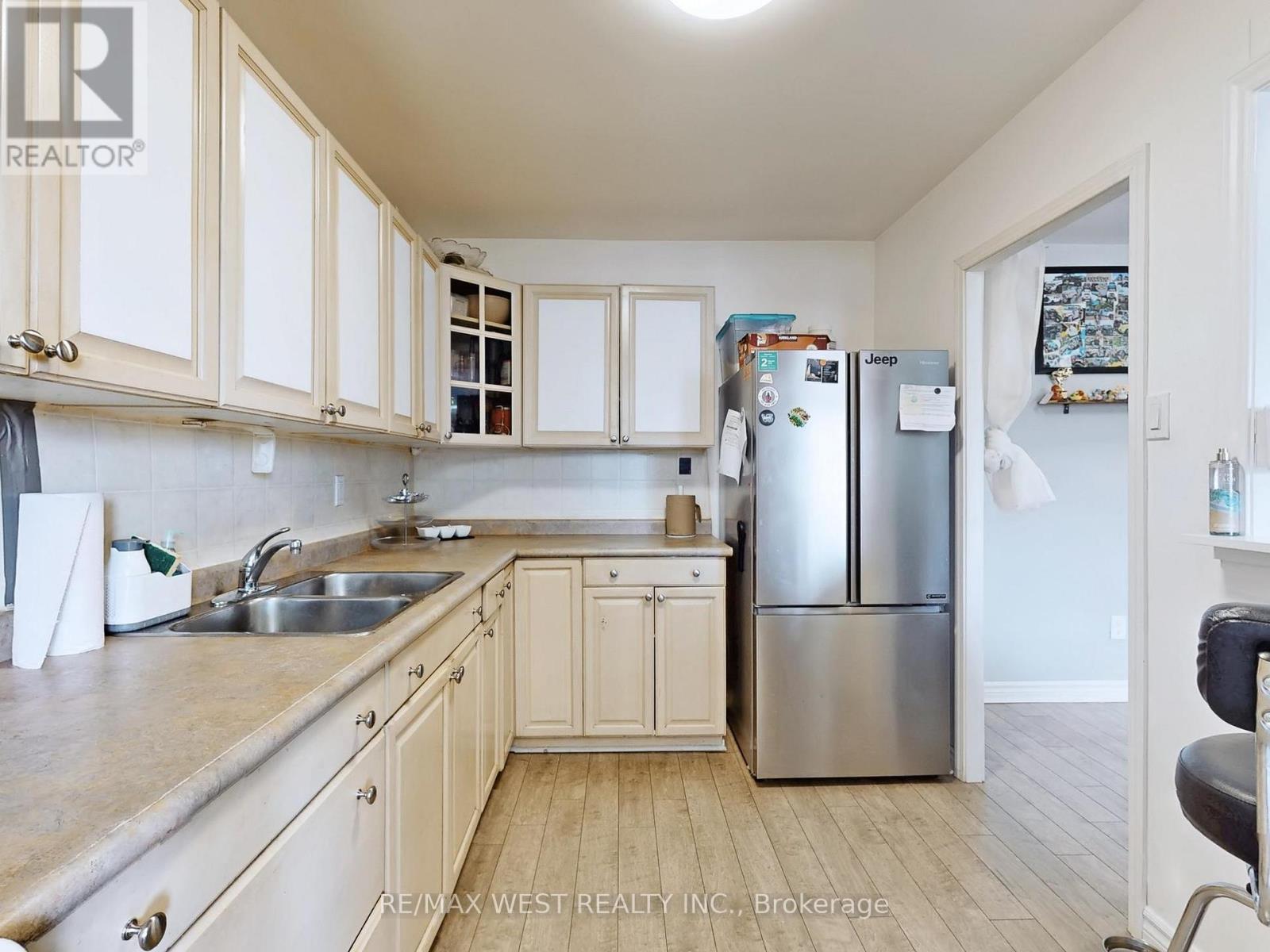 A kitchen with white cabinets and a stainless steel refrigerator.