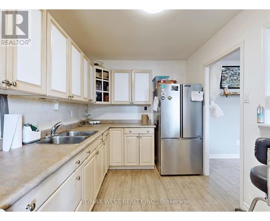 A kitchen with white cabinets and a stainless steel refrigerator.