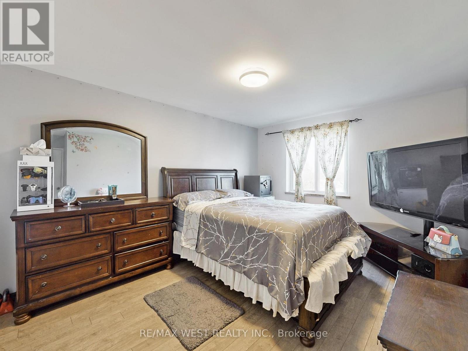 A bedroom with a bed, dresser, and mirror.