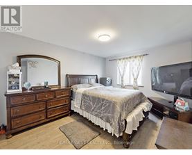 A bedroom with a bed, dresser, and mirror.