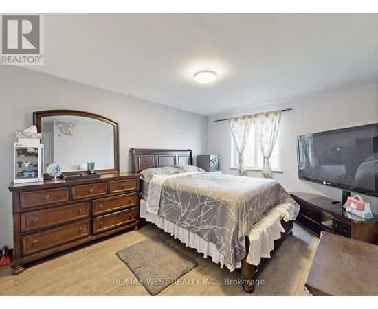 A bedroom with a bed, dresser, and mirror.