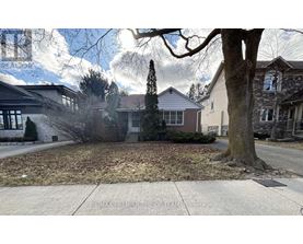 A tree stands in front of a house with a sign that says RE/MAX Premier The Opryland.