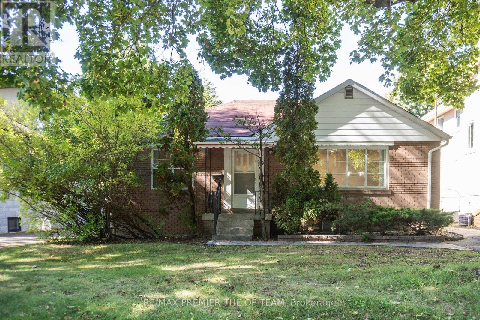 A house with a front yard and trees in the background.