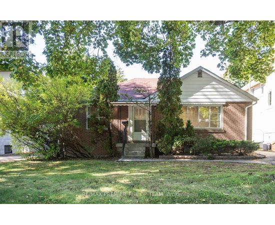 A house with a front yard and trees in the background.