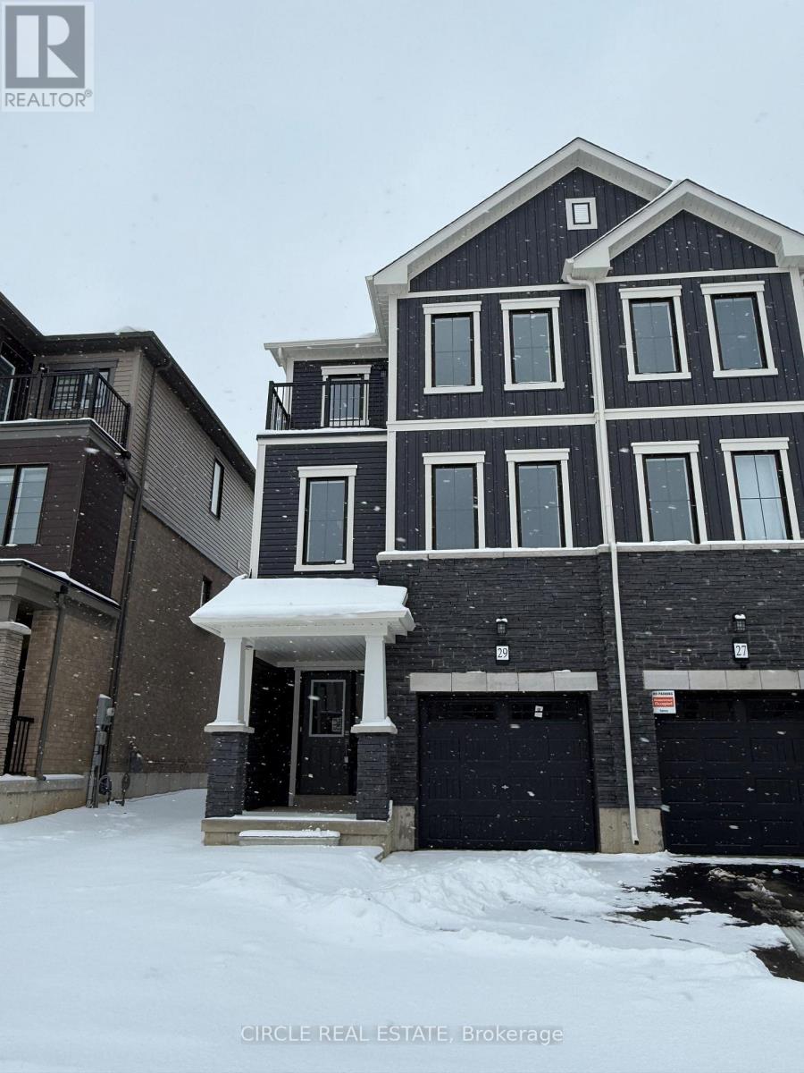 A large house with a black and white facade stands in the snow.