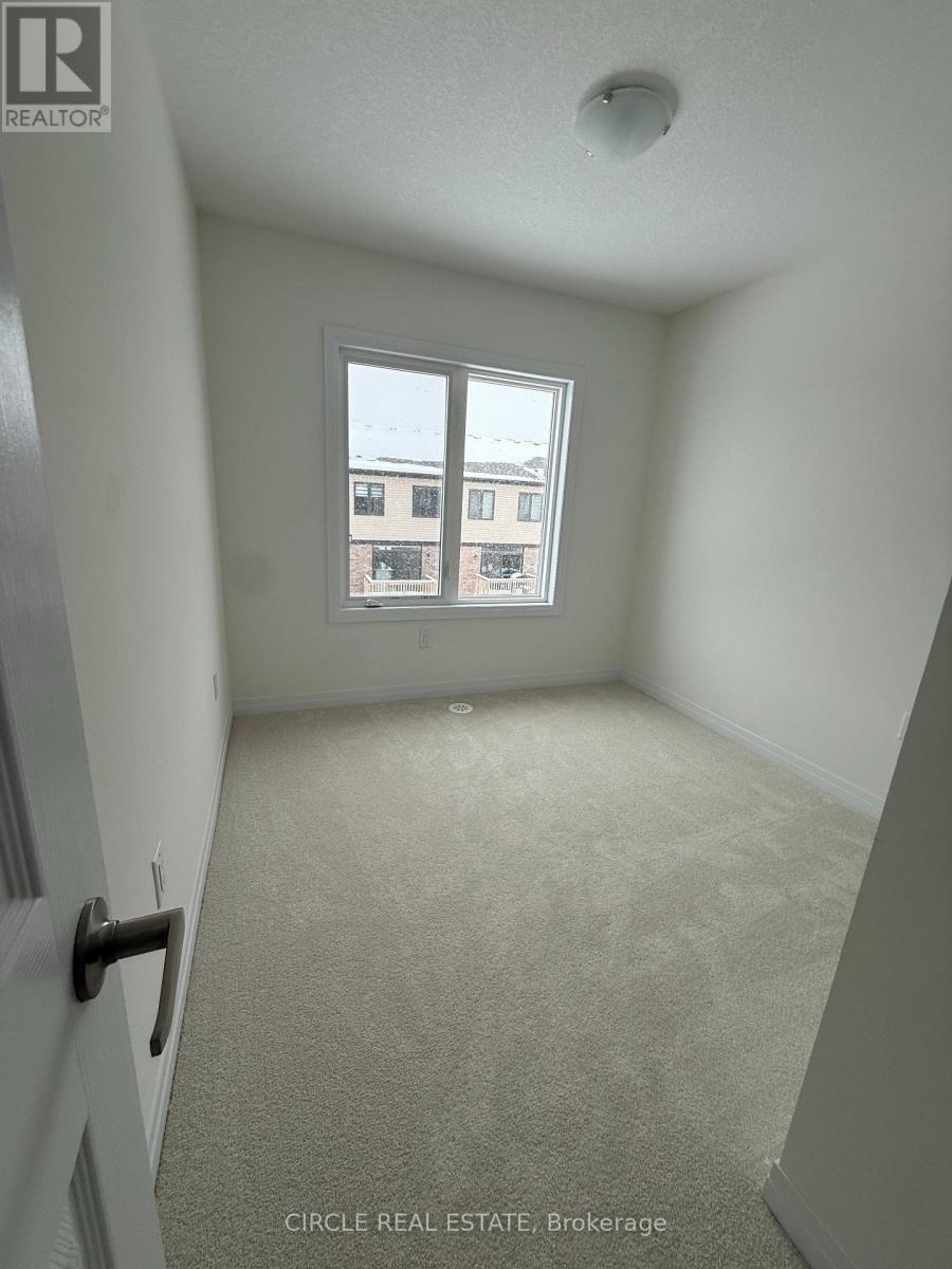 A room with a door and a window showing a building outside.