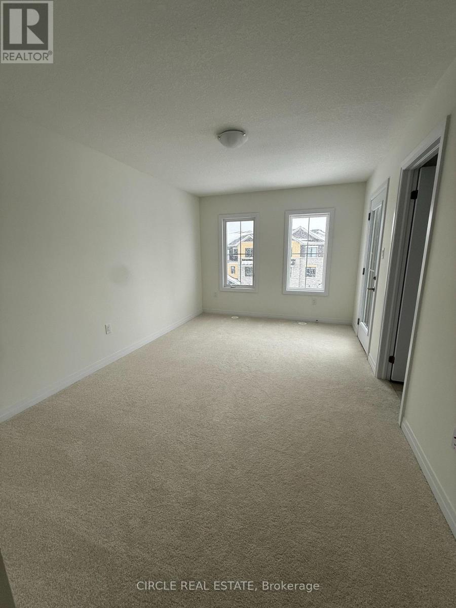 A spacious room with carpeted floor and two windows.