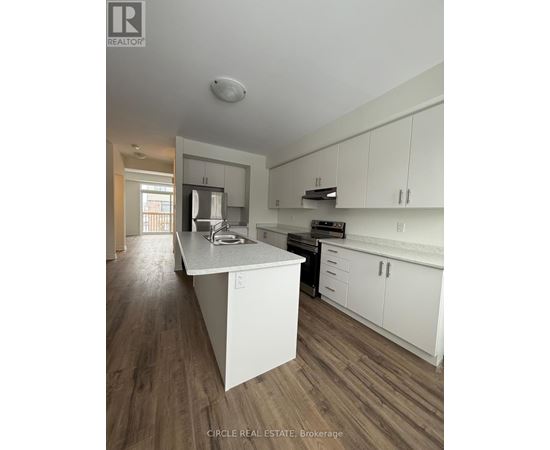 A kitchen with white cabinets and a wooden floor.