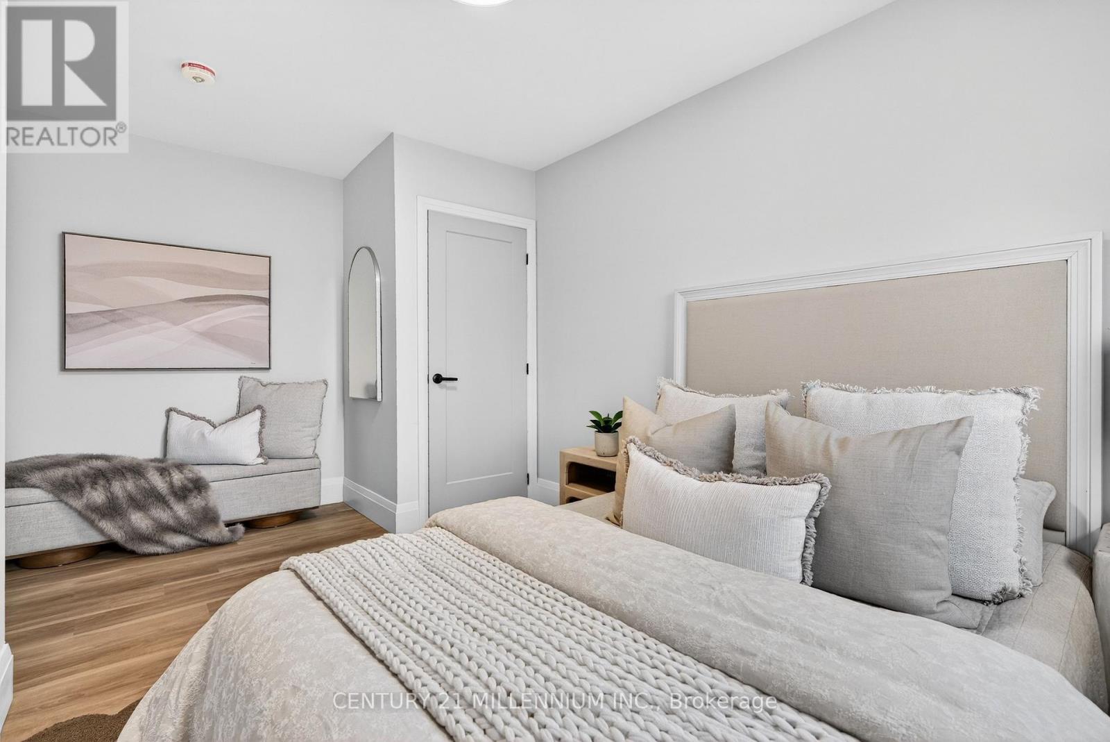 A bedroom with a large bed and a painting on the wall.