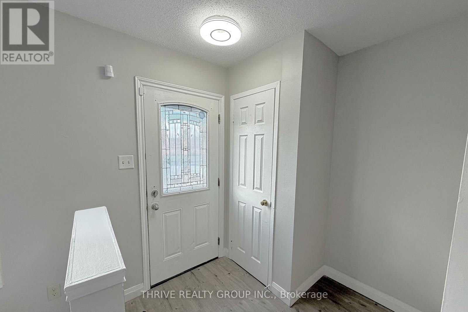 A white door with a window in the middle of a room.