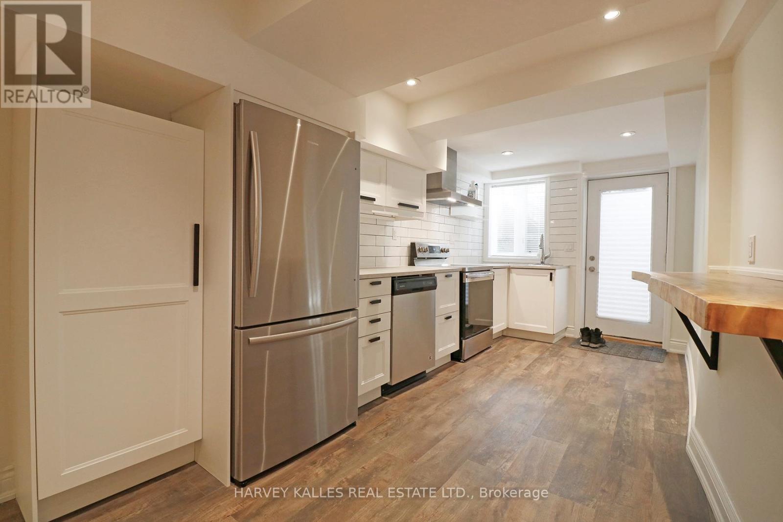 A kitchen with a refrigerator, stove, and sink.