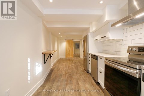 A kitchen with white cabinets and a wooden floor.