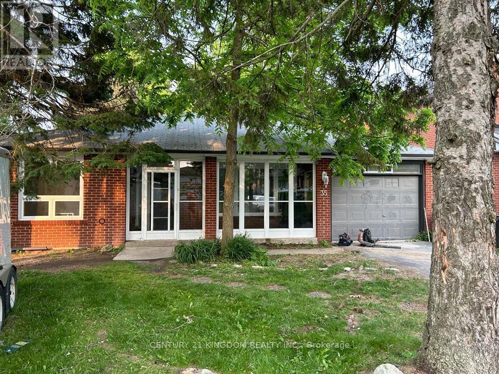 A tree is in front of a house.
