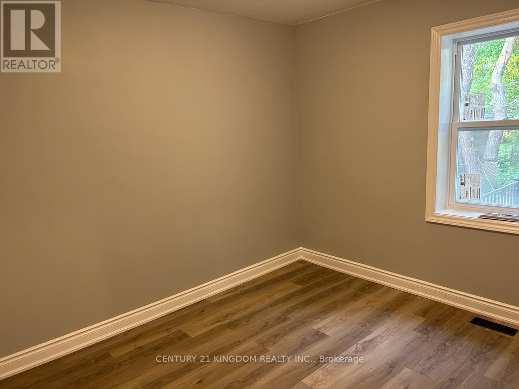 A room with a window showing a view of trees and a wall with a logo that says REALTOR.