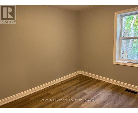 A room with a window showing a view of trees and a wall with a logo that says REALTOR.