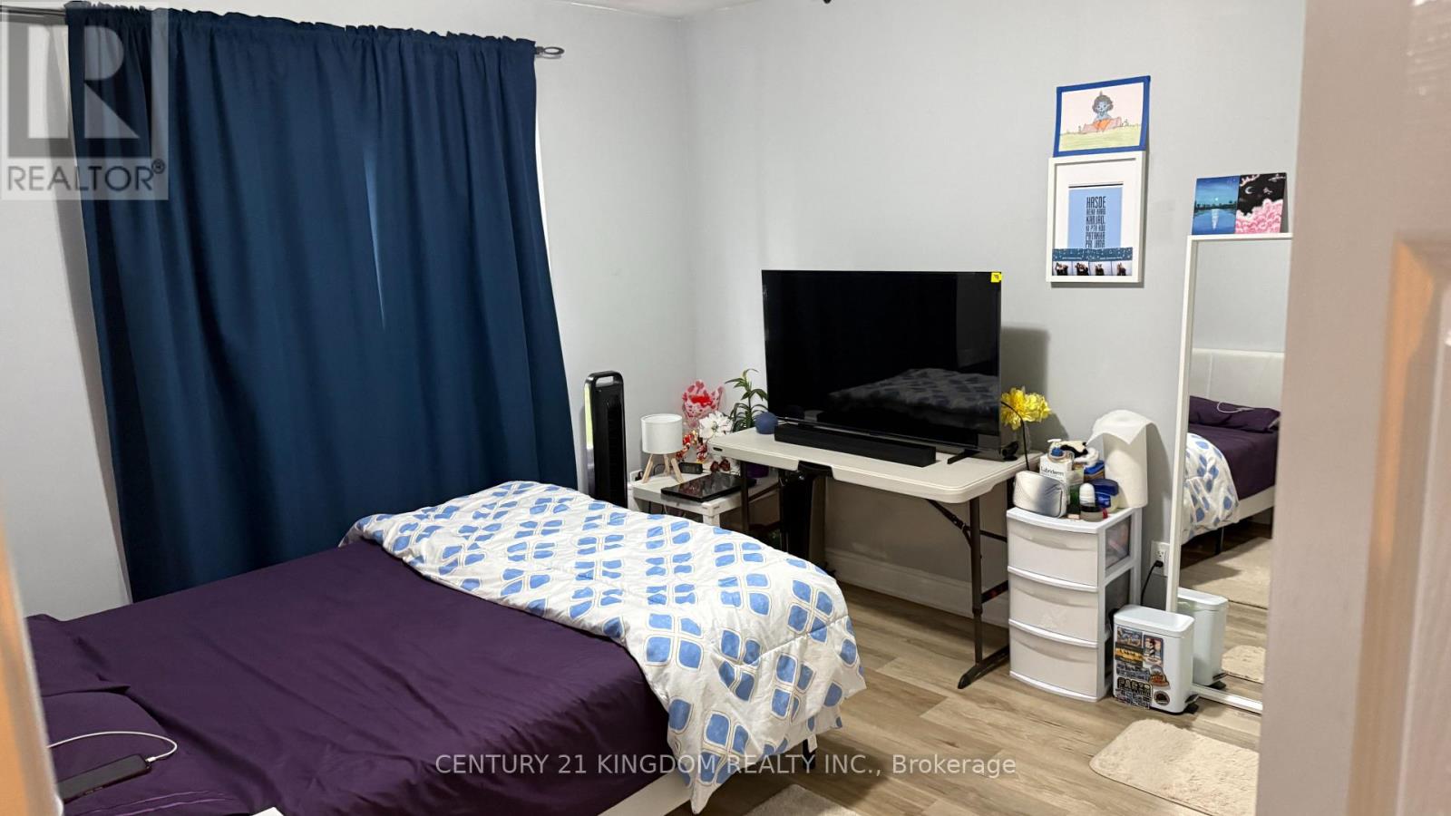 A bedroom with a bed, desk, and chair.
