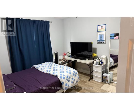 A bedroom with a bed, desk, and chair.