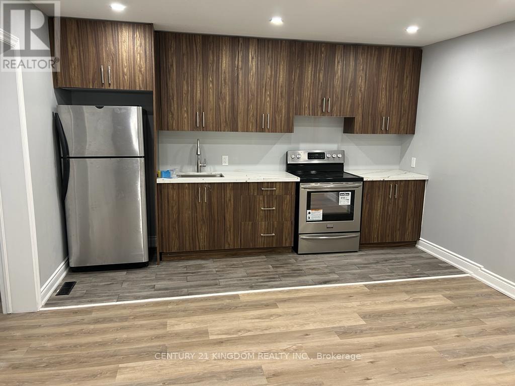 A kitchen with wooden cabinets and a stainless steel refrigerator.