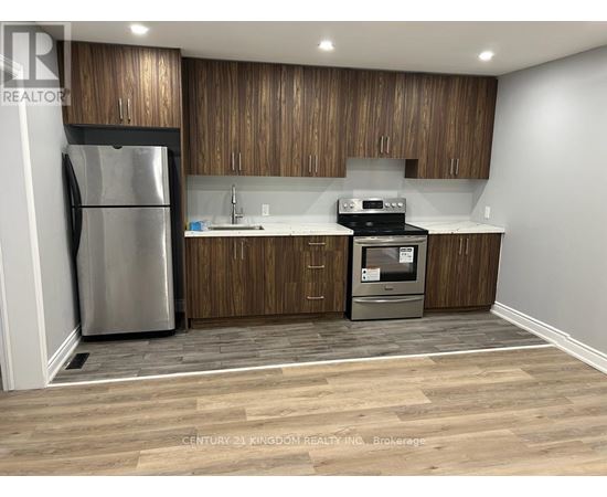 A kitchen with wooden cabinets and a stainless steel refrigerator.