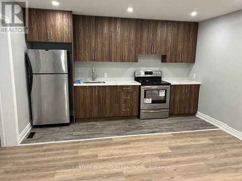 A kitchen with wooden cabinets and a stainless steel refrigerator.