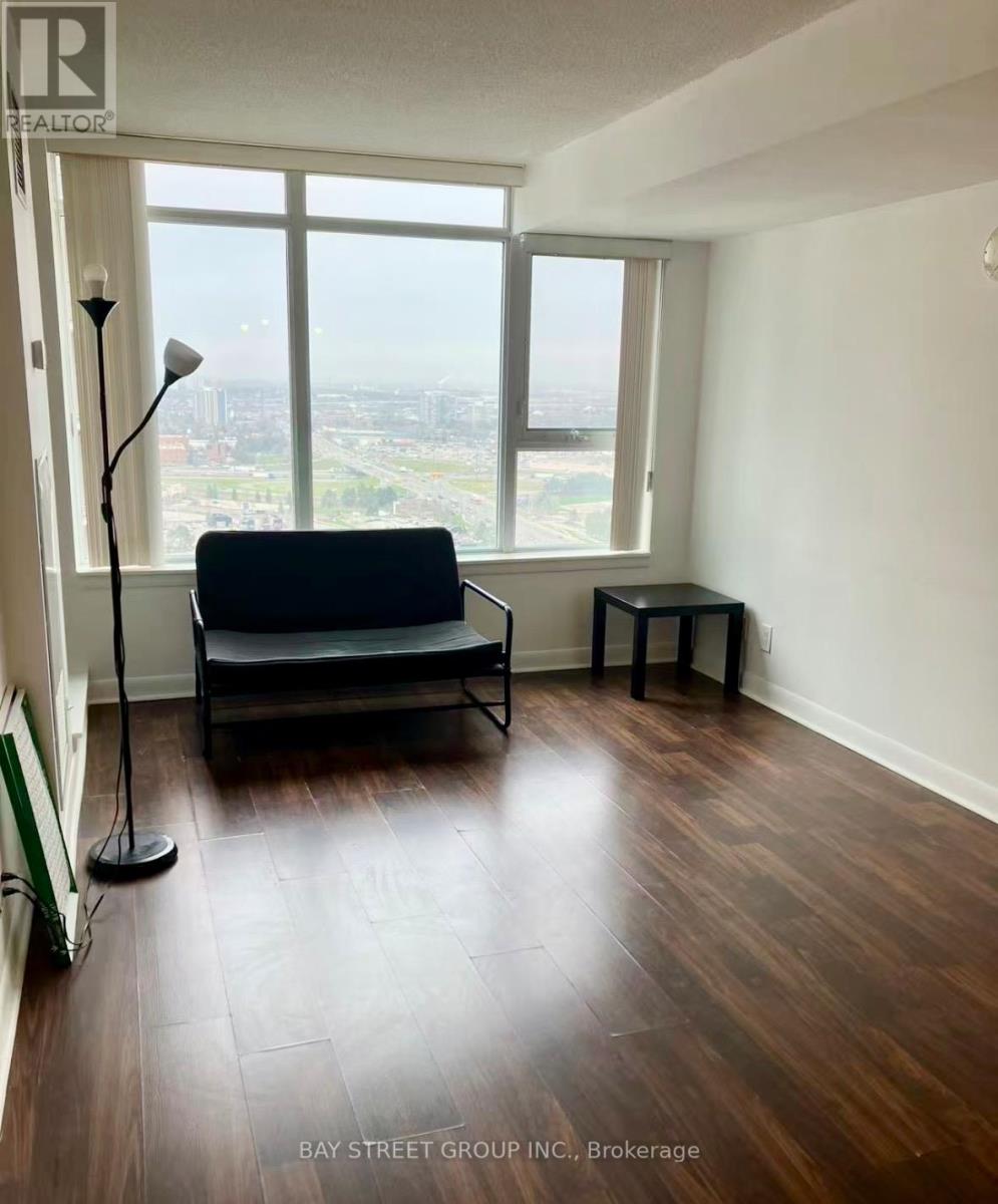 A living room with a couch, a small table, and a floor lamp.
