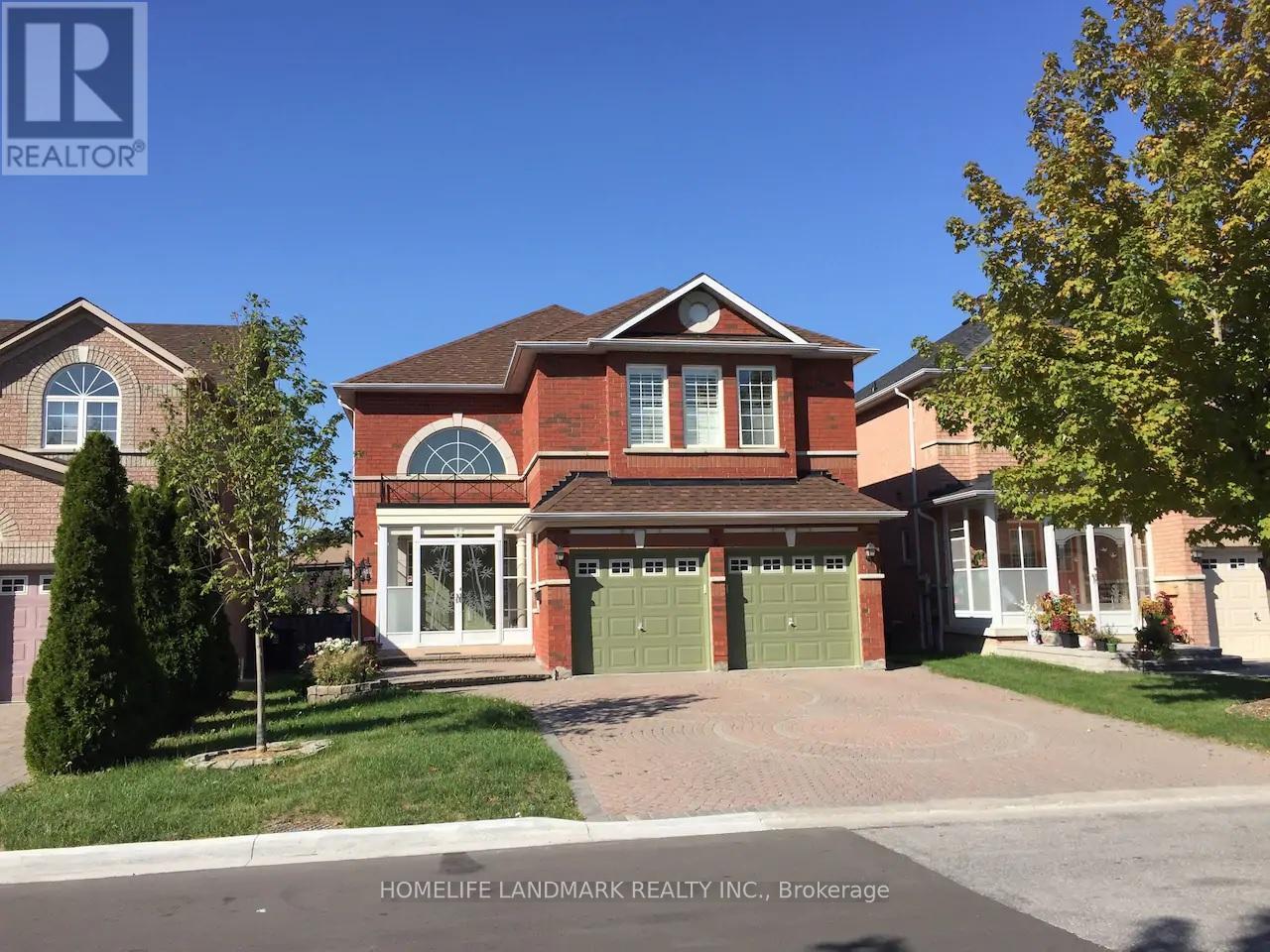 A large brick house with a green garage door is for sale.