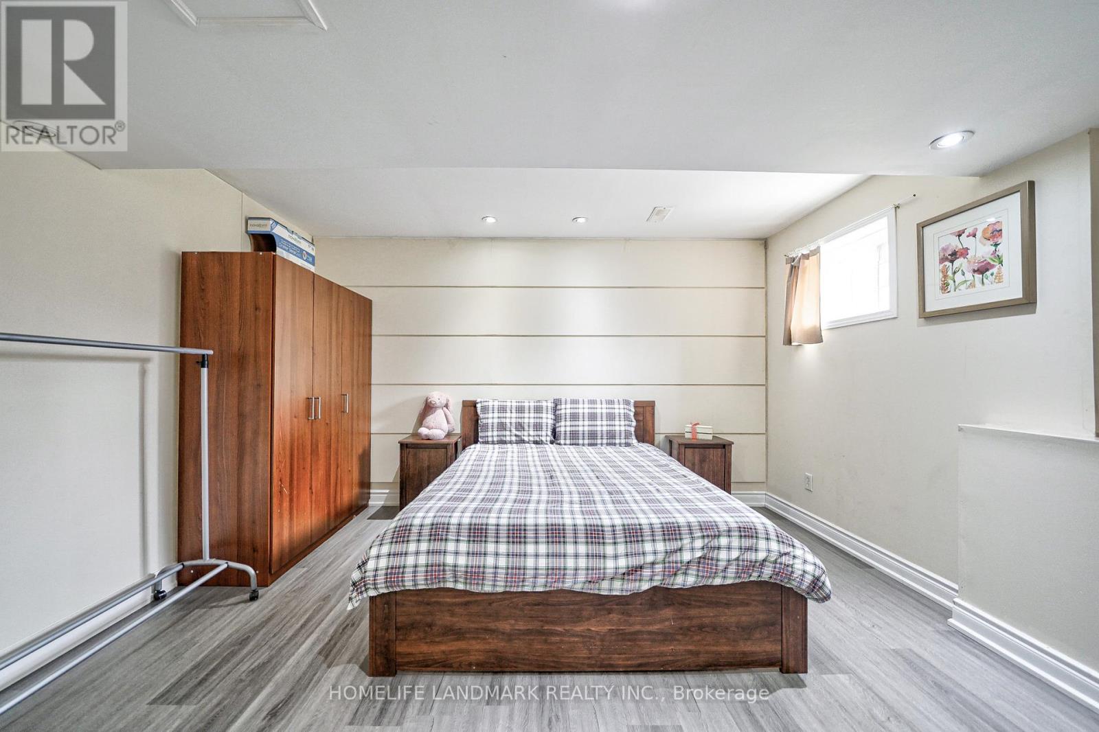 A bedroom with a large bed and a wooden headboard.