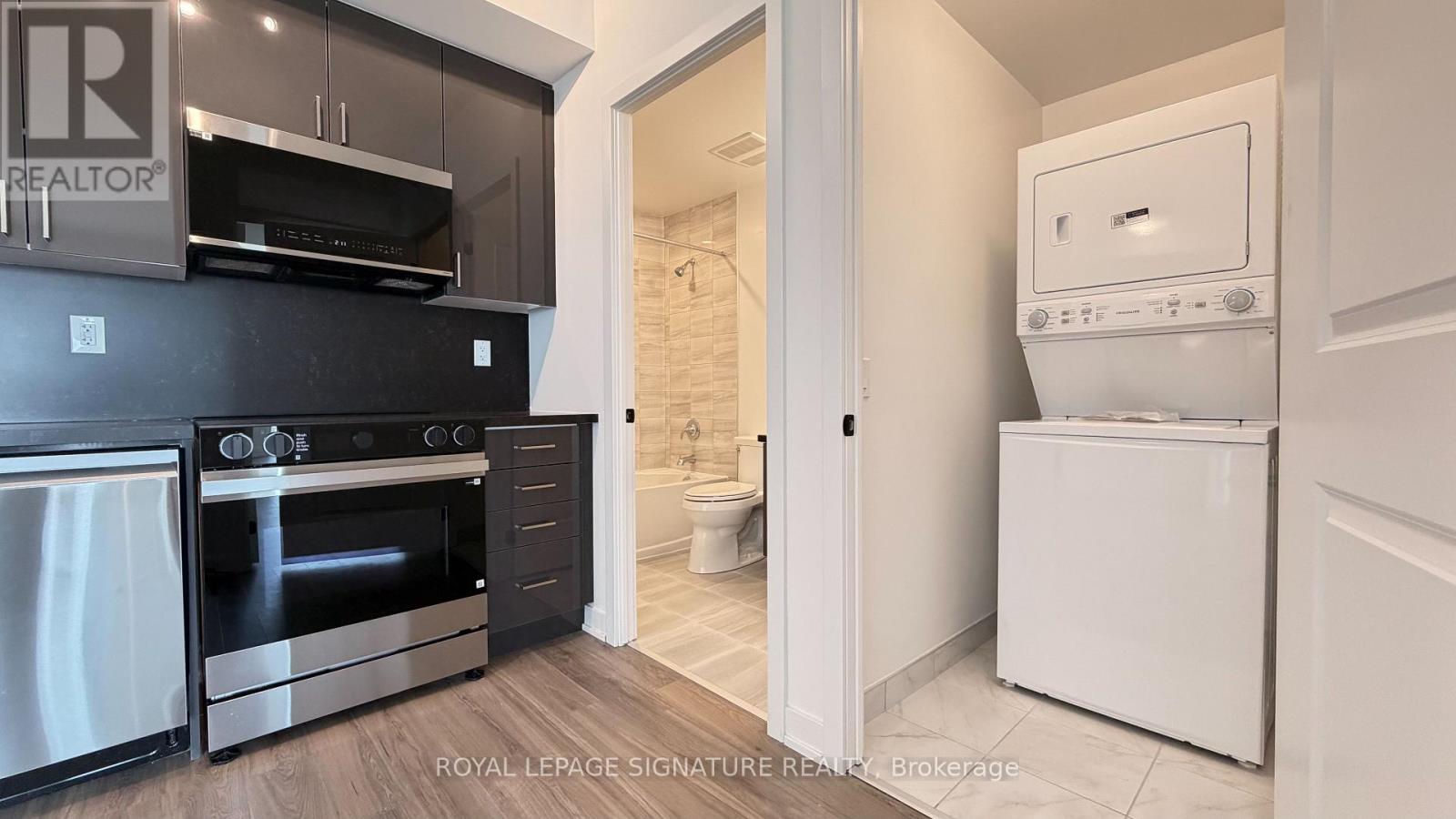 A kitchen with black cabinets and a white oven.