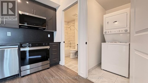 A kitchen with black cabinets and a white oven.