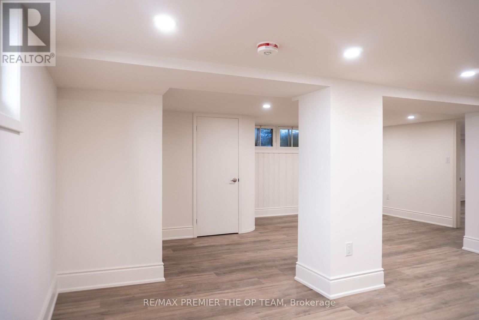 A spacious room with white walls and a wooden floor.