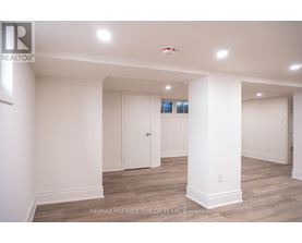 A spacious room with white walls and a wooden floor.