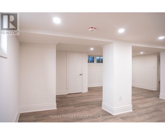 A spacious room with white walls and a wooden floor.