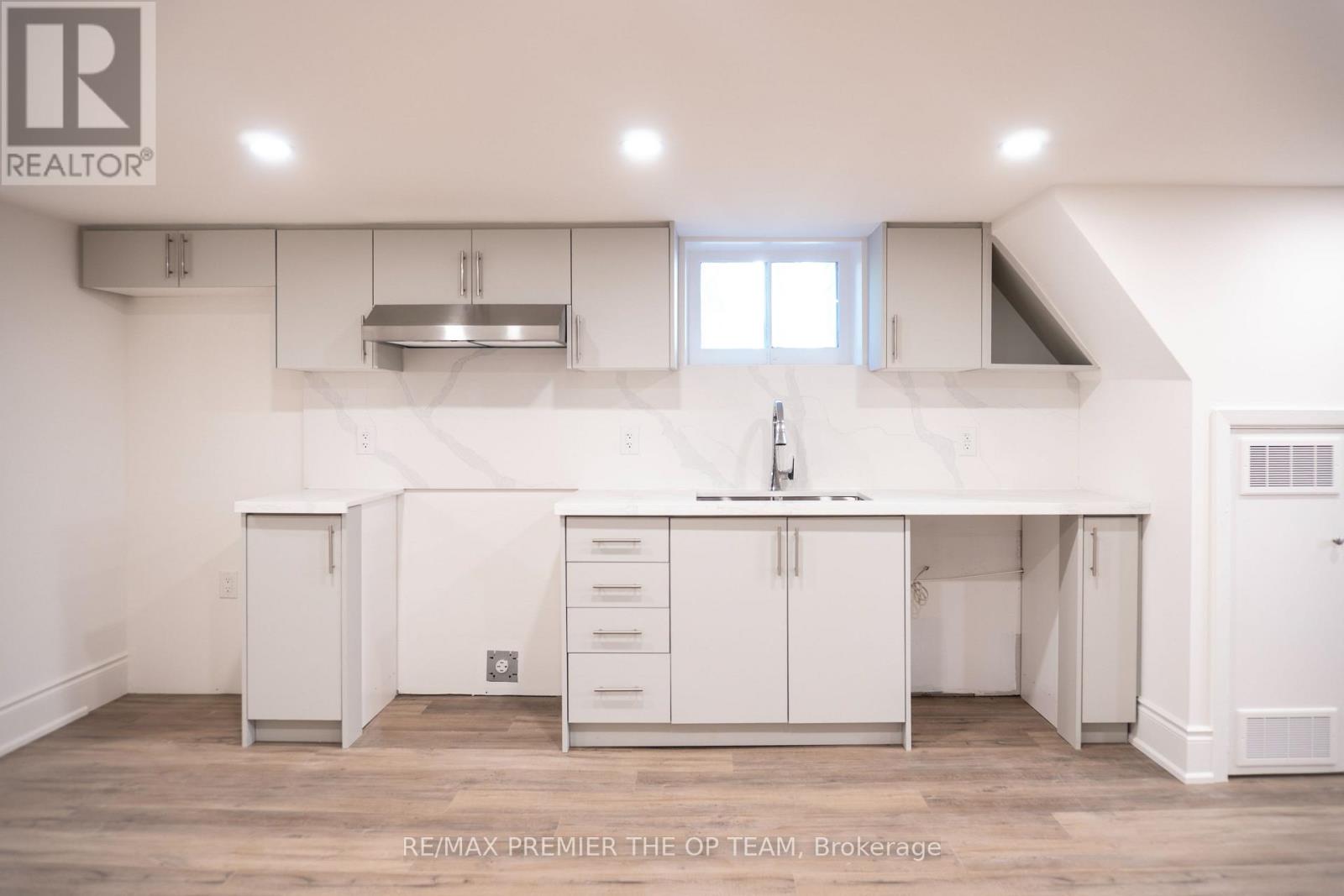 A white kitchen with a large island and a sink.
