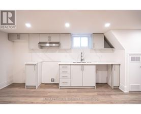 A white kitchen with a large island and a sink.