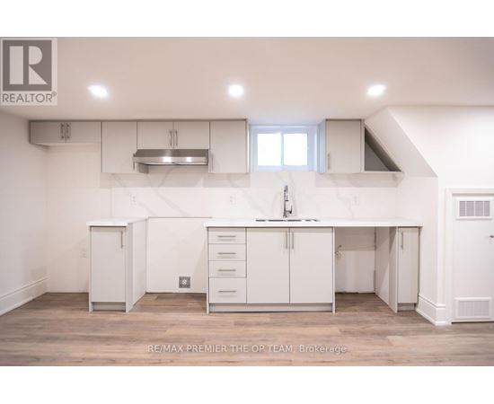A white kitchen with a large island and a sink.
