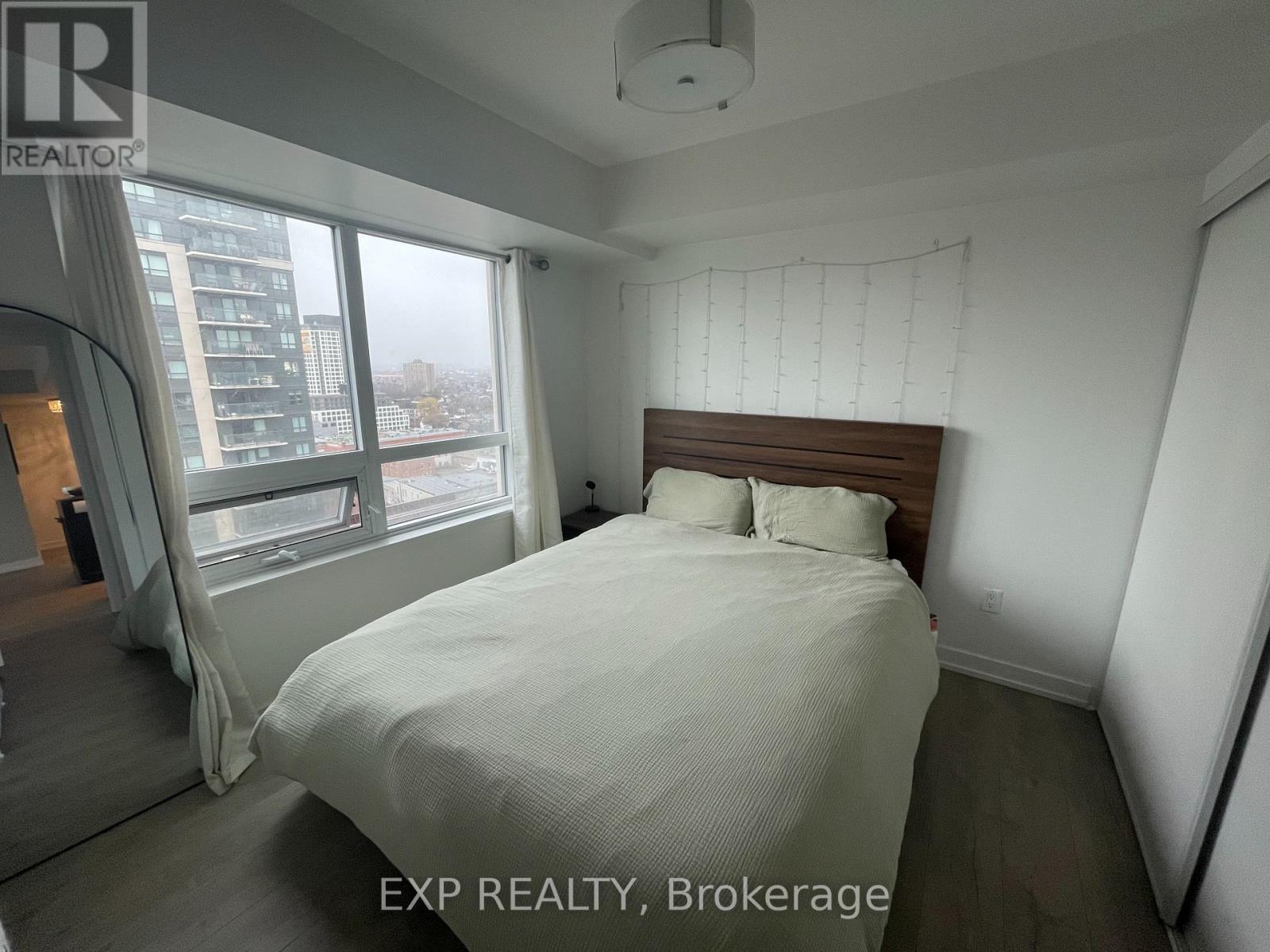A bedroom with a large bed and a view of the city.