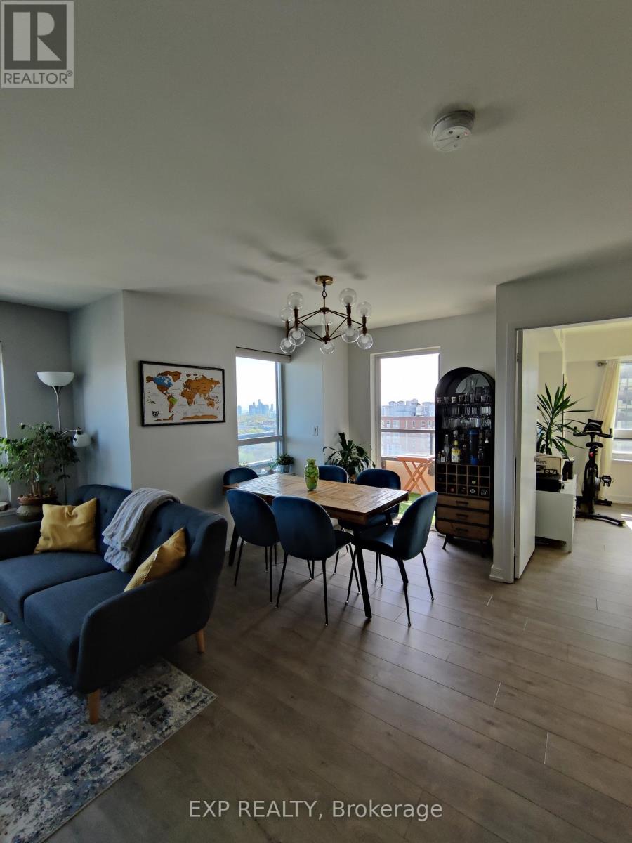 A living room with a blue couch and a dining table with chairs.