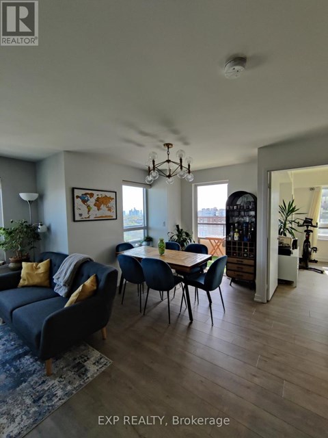 A living room with a blue couch and a dining table with chairs.