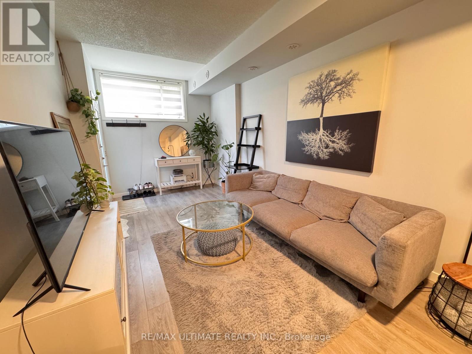 A living room with a large couch, a coffee table, and a television.