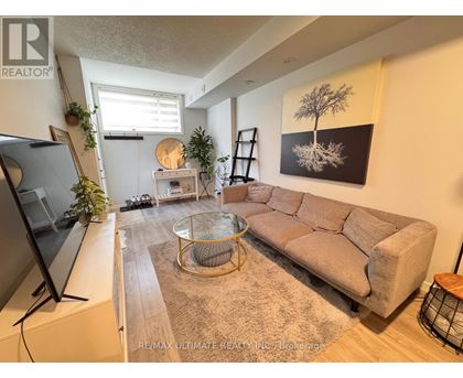 A living room with a large couch, a coffee table, and a television.