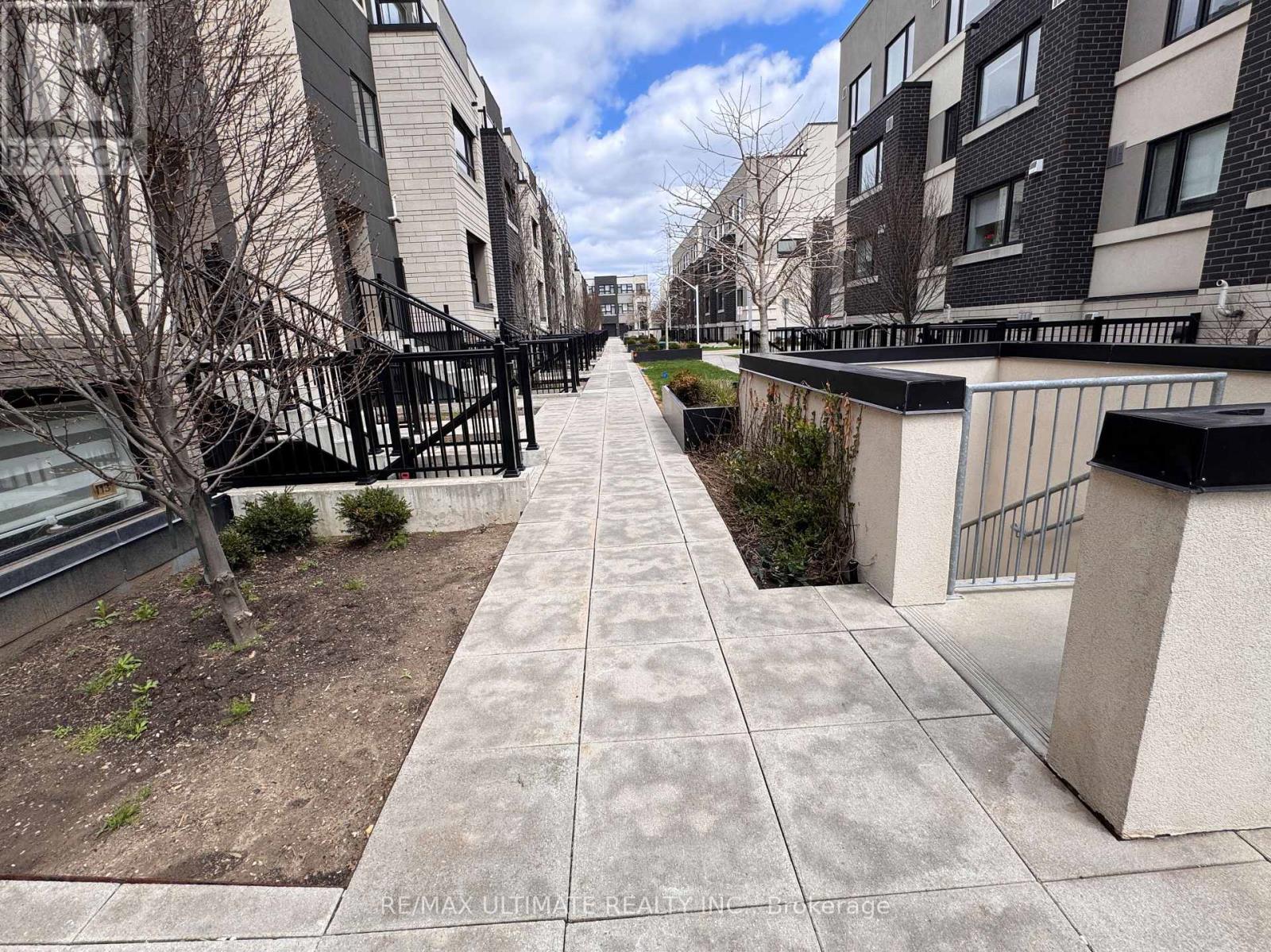 A long concrete walkway leads between two rows of apartment buildings.
