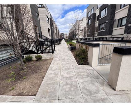 A long concrete walkway leads between two rows of apartment buildings.